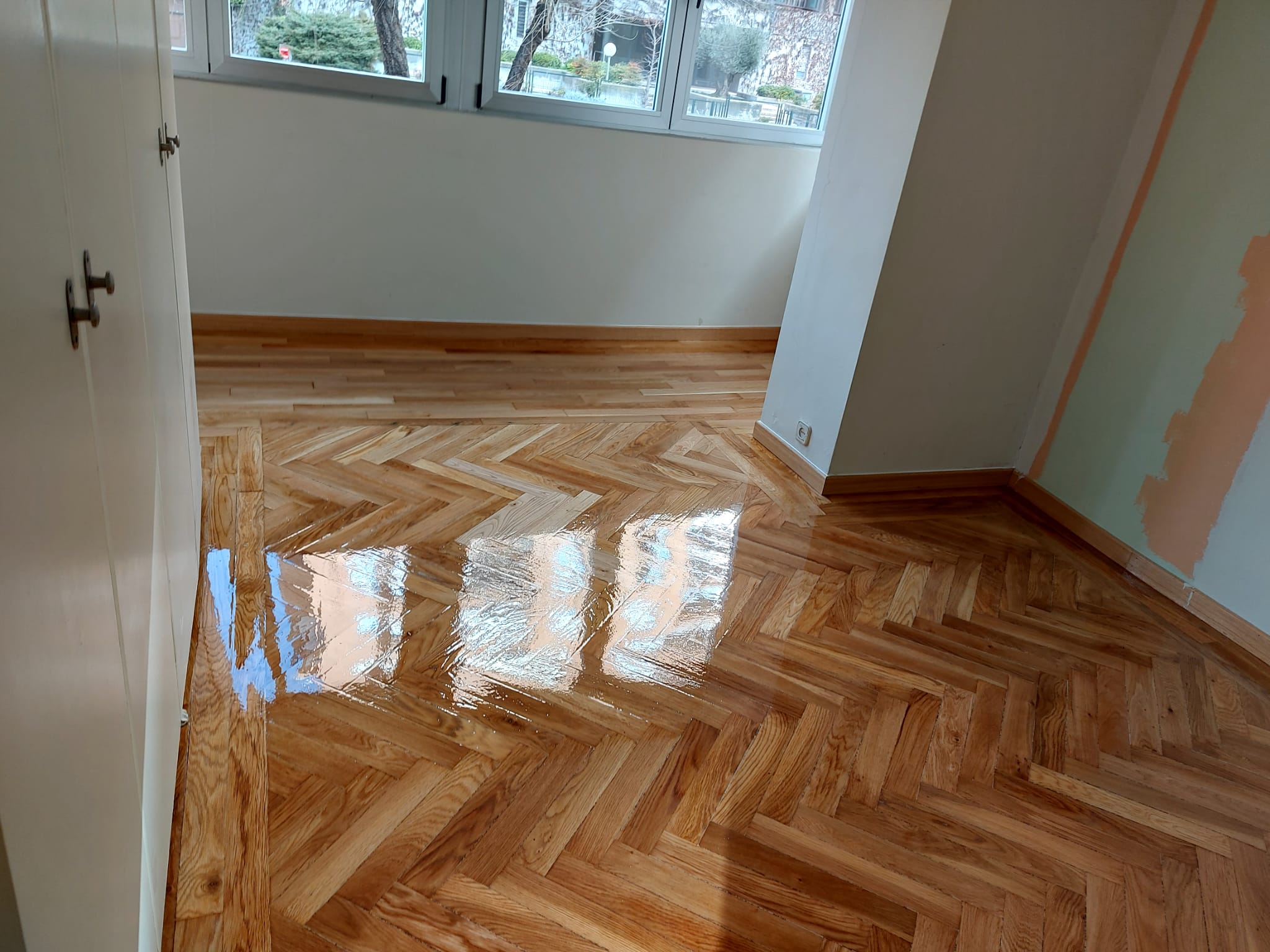 Parquet de espiga de madera natural barnizado con acabado brillante, instalado por Tarimas Remasol